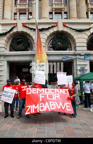 Anti-Mugabe Demonstranten halten einen "Demokratie für Simbabwe" Banner auf CHOGM 2011 Proteste in Perth. Stockfoto