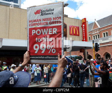 Demonstrant hält einen "Menschen brauchen nicht Corporate Gier" Banner neben einem Macdonald Zeichen. Stockfoto