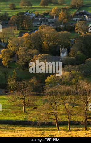 Die ersten Sonnenstrahlen treffen das bunte Herbstlaub Arncliffe in Littondale, Yorkshire Stockfoto