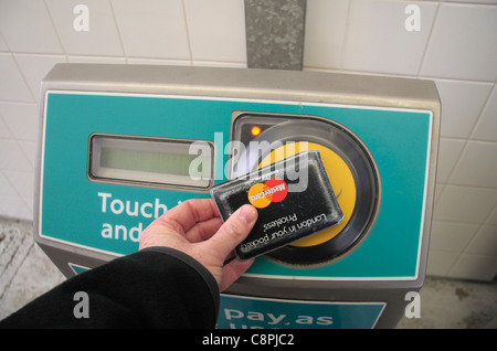 Ein Mann streichen seine Brieftasche (enthält eine Oystercard) auf eine berühren und Pay Leser an Pudding Mill Lane DLR Station, London, UK. Stockfoto