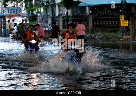 Bangkok Motorrad Taxis fahren Sie durch das Hochwasser aus dem Überquellenden Phra Khanong Canal, Sukhumvit Road, Soi 50, Bangkok, Thailand, South East Asia am 30. Oktober 2011. Thailand erlebt die schlimmste Überschwemmung in mehr als 50 Jahren. © kraig Lieb Stockfoto