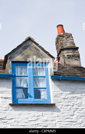 Das blaue Fenster und gebogenen Schornstein einer weißen Hütte im Dorf von Boscastle, Cornwall, England, UK Stockfoto