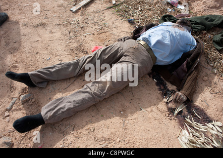 Eines Oberst Gaddafis Wachen legt Toten in den Straßen auf Sirt nach einem NATO-Luftangriff auf Gaddafi-Konvoi. Stockfoto