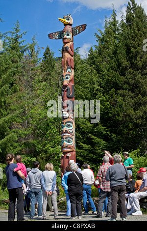 Touristen, die einen Totempfahl zu betrachten. Saxman Totem Park. Ketchikan. Alaska. USA Stockfoto