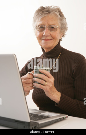 Eine ältere Frau mit einem Laptop. Stockfoto