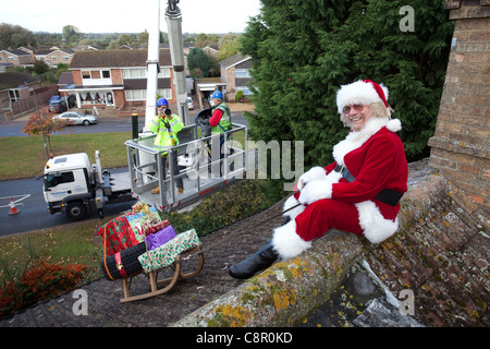 Santa Claus liefert seine Dach Top Magie mit Hilfe einer Hubarbeitsbühne UK Stockfoto