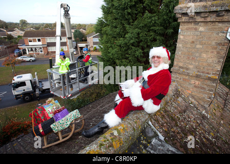 Santa Claus liefert seine Dach Top Magie mit Hilfe einer Hubarbeitsbühne UK Stockfoto