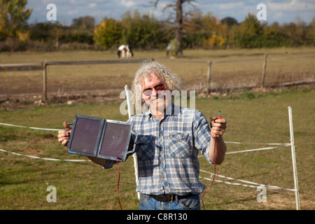 Ein Mann hält eine Solarpanel Ladegerät zeigt die Verbindungen UK Stockfoto