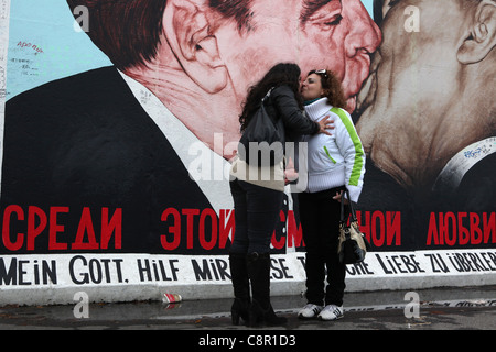 Coupé küssen vor Leonid Brezhnev und Honeckers Kuss auf die Berliner Mauer in der East Side Gallery in Berlin, Deutschland. Stockfoto