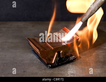 heruntergekommenen CPU Kühlkörper auf metallischen Boden beim Brennen mit Schweißbrenner Stockfoto