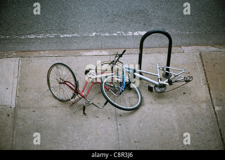 Verfallene und verlassene Fahrräder angekettet an einem Fahrradständer im New Yorker Stadtteil Chelsea Stockfoto