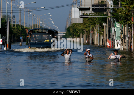 Bangkok-Bewohner waten am Montag, den 31. Oktober 2011, durch gefährliche Überschwemmungen auf der Phahon Yothin Road, Bangkok, Thailand, Südostasien. Thailand erlebt die schlimmsten Überschwemmungen seit mehr als 50 Jahren. Danksagung: Kraig lieb Stockfoto