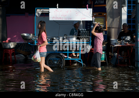 Einwohner Bangkoks waten am Montag, den 31. Oktober 2011, durch Hochwassergewässer auf der Phahon Yothin Road, Bangkok, Thailand. Thailand erlebt die schlimmsten Überschwemmungen seit mehr als 50 Jahren. © Kraig Stockfoto