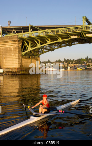 Person Ruderplatz Ruderboot am Fluss unter der Brücke Stockfoto
