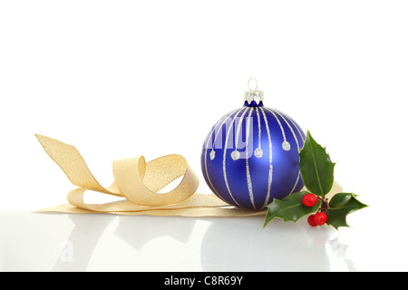 Blaue Weihnachten Christbaumkugel gold Ribbon und einen Zweig der Stechpalme mit weichen Schatten und Reflexionen Stockfoto