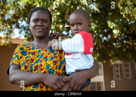 Eine Frau hält ihr Kind außerhalb des Opfers häuslicher Gewalt Zuflucht in Pallisa, Uganda, Ostafrika. Stockfoto