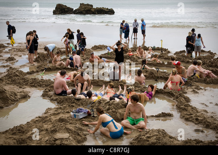 Touristen Graben nach Thermalquellen am Hot Water Beach, Neuseeland Stockfoto