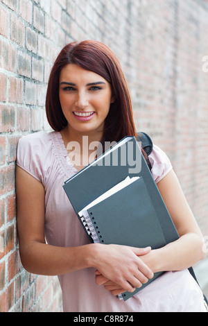 Porträt eines glücklichen Studenten halten ihr Bindemittel Stockfoto