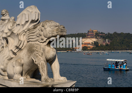 Stein-Löwen auf 17 Bogenbrücke über Kunming-See mit Paddel Bootsfahrer im Summer Palace Beijing Volksrepublik China Stockfoto