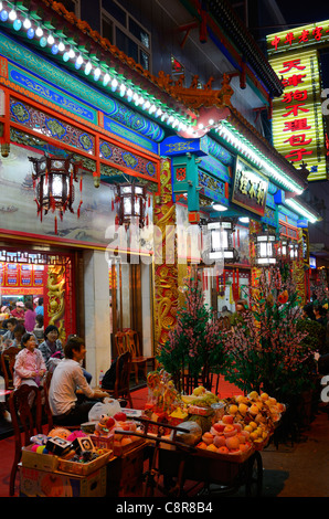 Chinesische Familie sitzt vor einem Restaurant von Straßenhändlern in der Nacht in Peking Volksrepublik China Stockfoto