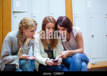 Schüler zeigen eine SMS-Nachricht an ihre Freunde Stockfoto