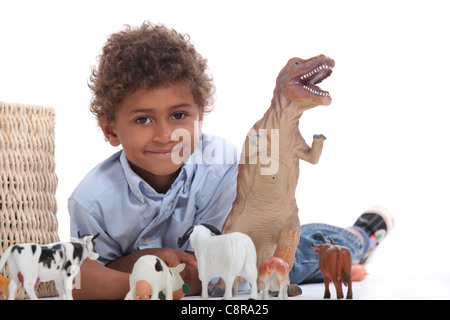 Jungen spielen mit einem Spielzeug Dinosaurier und Sammlung von Haustieren Stockfoto