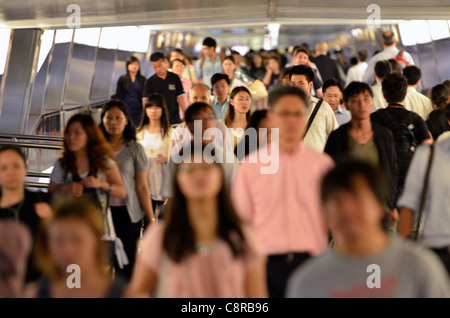 Massen von chinesischen Büroangestellten fließt entlang einen erhöhten Laufsteg im central Business District. Stockfoto