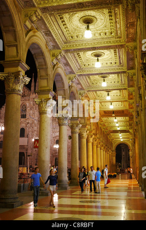 Die Leute laufen in der Kolonnade des Palazzo dei Portici Meridionali in Nignt. Piazza del Duomo, Mailand, Italien. Stockfoto
