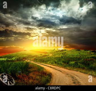 schöne Aussicht auf den Sonnenuntergang in einem Feld auf einer ländlichen Straße Stockfoto