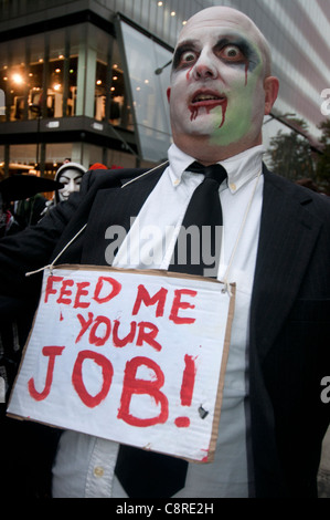 Halloween. Zombie-Banker März aus dem Lager besetzen London. Man hat ein Schild mit der Aufschrift feed me Ihren job Stockfoto