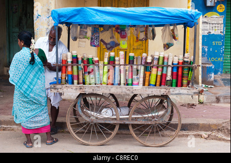 Indischer Mann Armreifen aus einem Holzkarren auf einer indischen Straße zu verkaufen. Puttaparthi, Andhra Pradesh, Indien Stockfoto