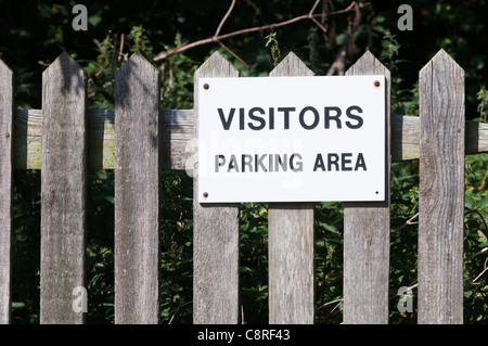 Ein Schild an einem Holzzaun liest Besucher-Parkplatz Stockfoto