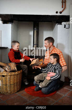 Eine Familie mit einer Festbrennstoff Holzverbrennung Herd um ihre Haus-UK zu heizen Stockfoto