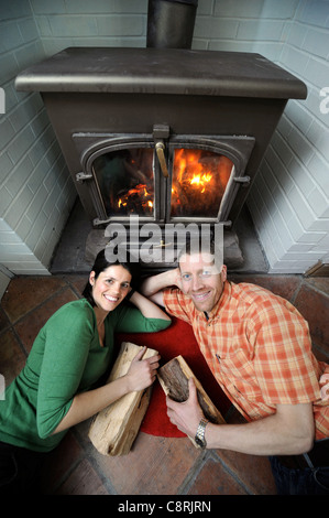 Eine Familie mit einer Festbrennstoff Holzverbrennung Herd um ihre Haus-UK zu heizen Stockfoto