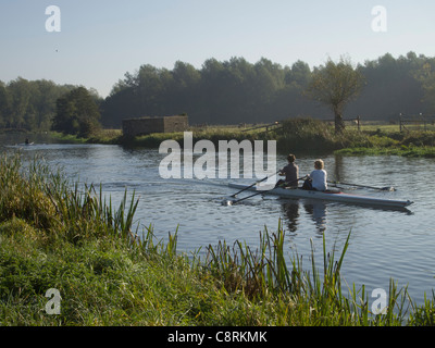 Zwei Personen in einem Kanu rudern, in den frühen Morgenstunden, am Fluss Stour in Sudbury in Suffolk, England. Stockfoto