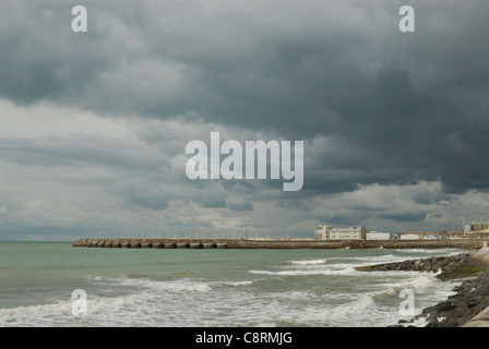 Ein Blick auf Brighton Marina Meer Mauer, an einem stürmischen Tag mit dunklen Wolken in den Himmel-Overhead. Stockfoto