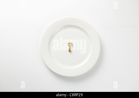 Goldener Schlüssel auf Platte Stockfoto