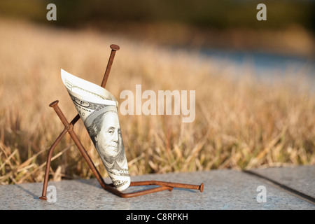 Gefaltete American Banknote zusammen mit Nägeln, im freien Stockfoto