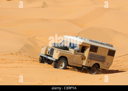 Afrika, Tunesien, nr. Tembaine. Land Rover Serie 2a Camper van durchqueren eine Sandfield mit Dünen in der Nähe von Tembaine auf... Stockfoto