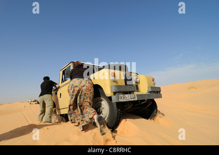 Afrika, Tunesien, nr. Tembaine. Wüste Touristen drängen eine stecken 1964 Land Rover Serie 2a-LKW-Fahrerhaus zurück auf festen Boden... Stockfoto