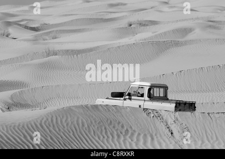 Afrika, Tunesien, nr. Tembaine. Wüste Reisende Fahrerhaus ein 1964 Land Rover Serie 2a LKW durch eine Sandfield nah an... Stockfoto