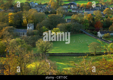 Die ersten Sonnenstrahlen treffen das bunte Herbstlaub Arncliffe in Littondale, Yorkshire Stockfoto