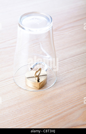 Glas auf dem Kopf stehend mit Schloss und Schlüssel in Stockfoto