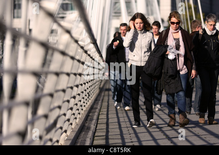 eine niedrige Aussicht entlang der Golden Jubilee Bridge, London, mit Menschen zu Fuß in Richtung der Kamera Stockfoto