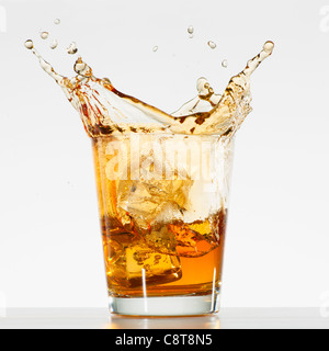 Studioaufnahme von Eiswürfeln Spritzwasser in Glas whiskey Stockfoto