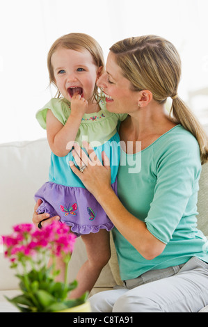 Mutter mit Tochter auf Sofa spielen Stockfoto