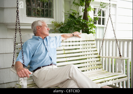 USA, New York State, Old Westbury, Senior Mann sitzt auf der Veranda-Schaukel Stockfoto