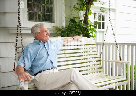 USA, New York State, Old Westbury, Senior Mann sitzt auf der Veranda-Schaukel Stockfoto