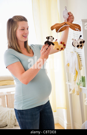 USA, New Jersey, Jersey City, schwangeren Frauen halten mobile im Kinderzimmer Stockfoto