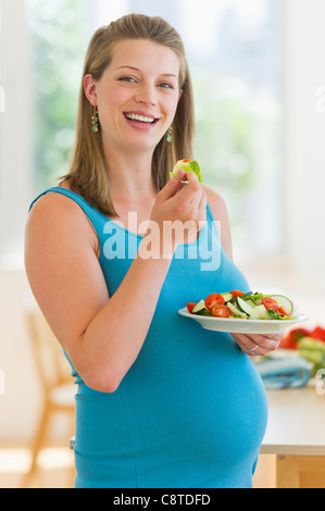 USA, New Jersey, Jersey City, junge schwangere Frau mit Salat Stockfoto